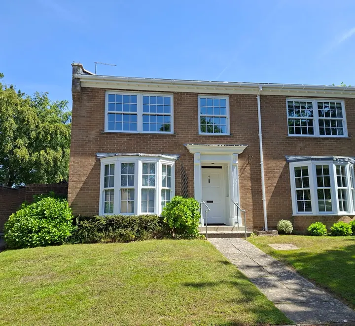 Repainted end-of-terrace home in Bransgore with white bay windows